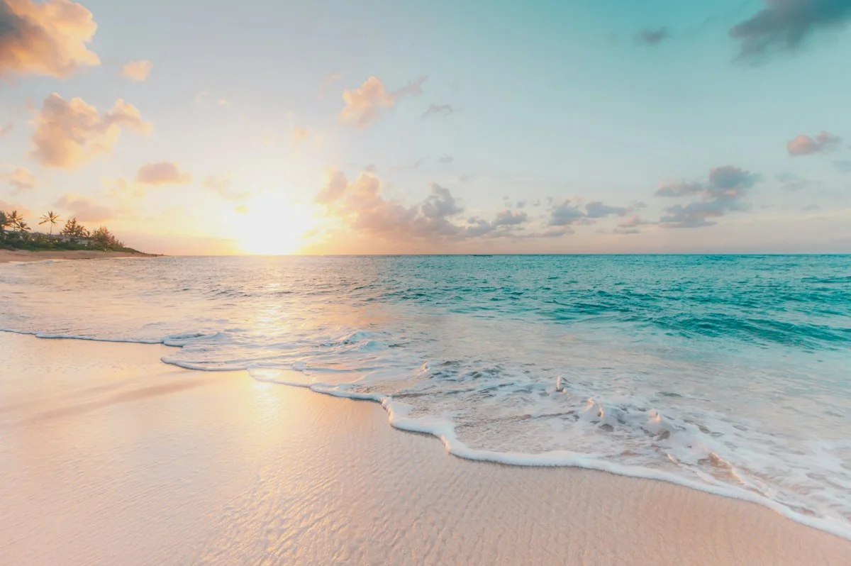 Gentle surf on a sandy beach at sunset