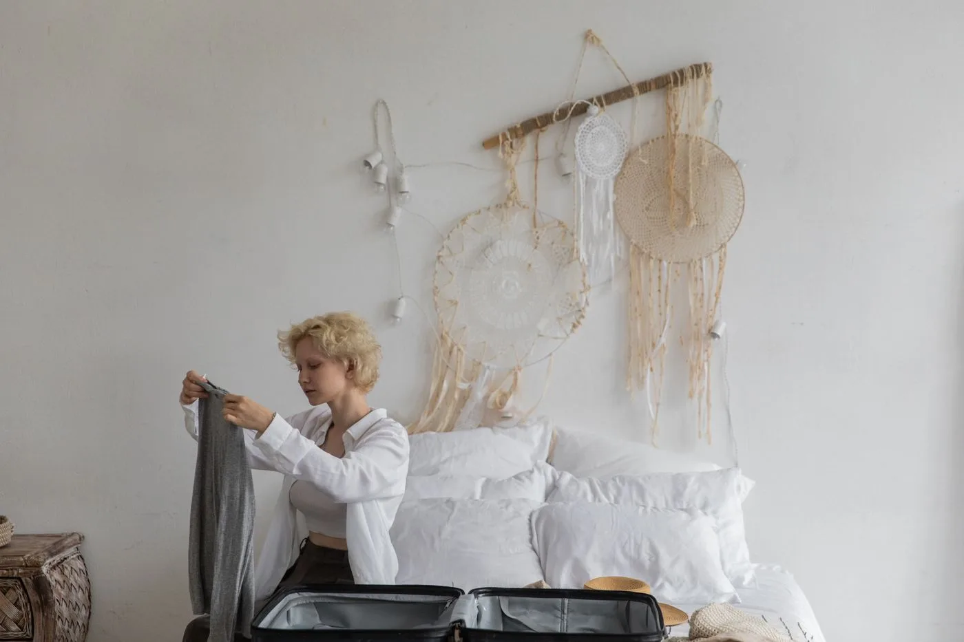 Woman packing a suitcase on a bed in a bedroom