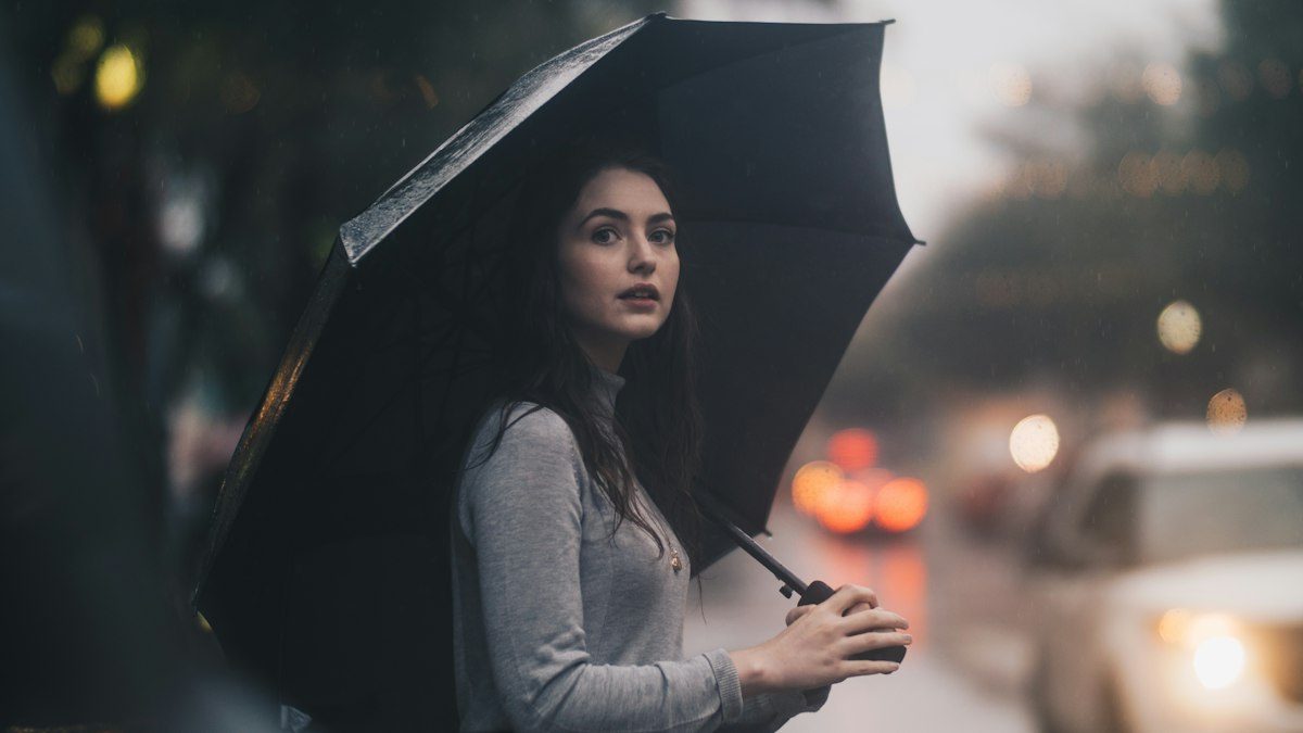Woman holding an umbrella on a rainy city street