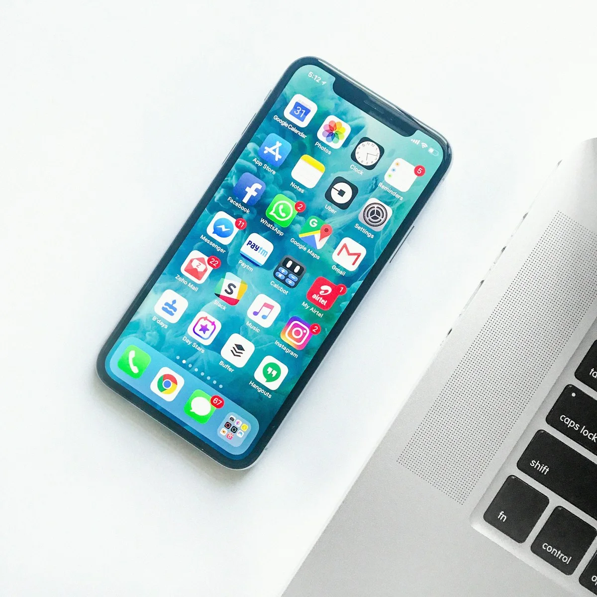 Smartphone lying beside a laptop keyboard