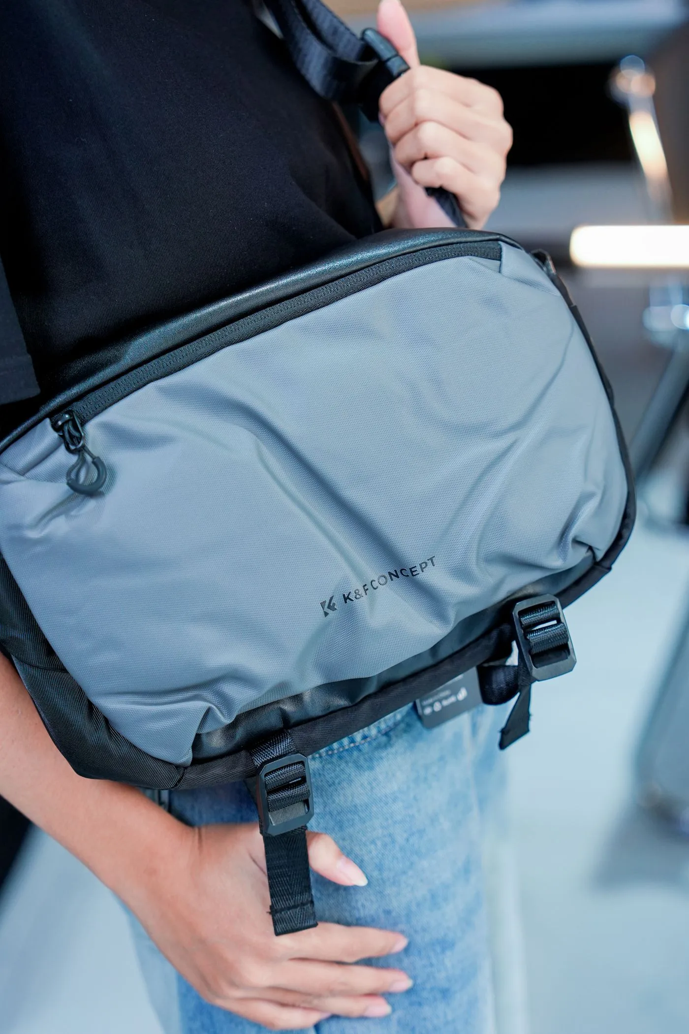 Grey messenger bag lying on a pale surface