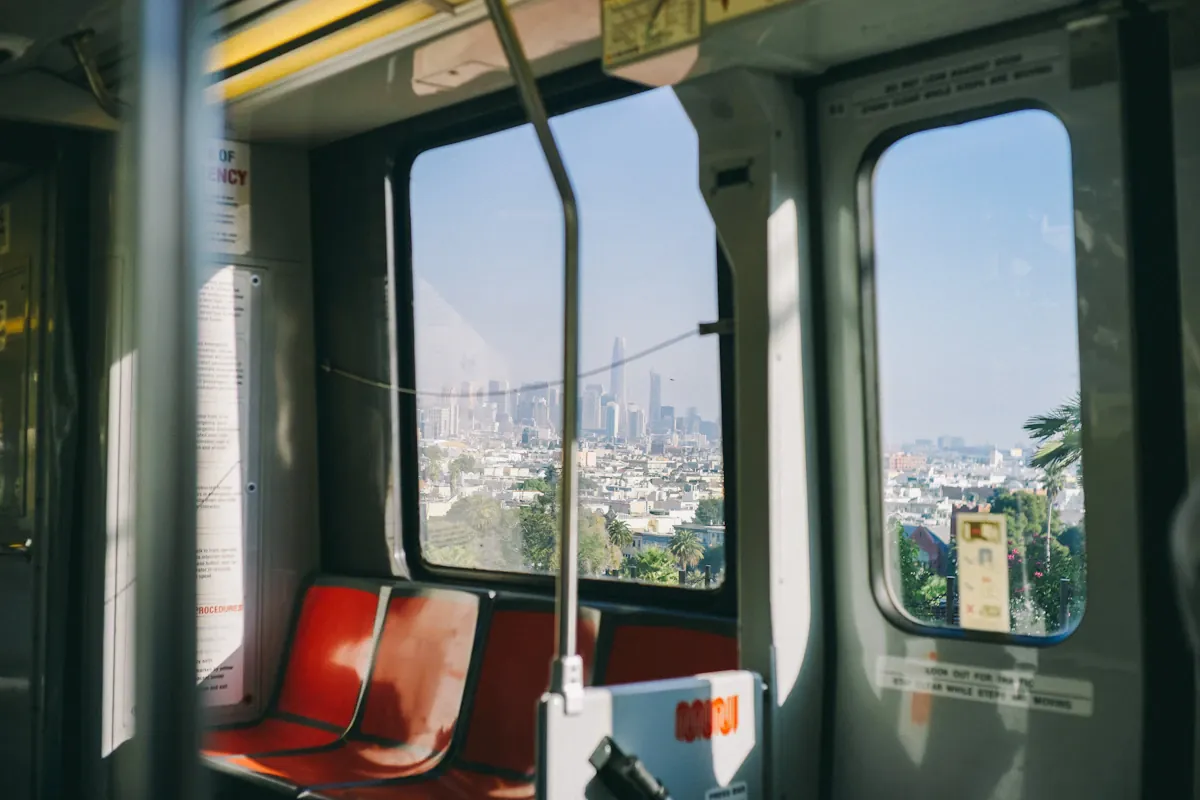 Red and grey seats beside windows inside a passenger rail vehicle