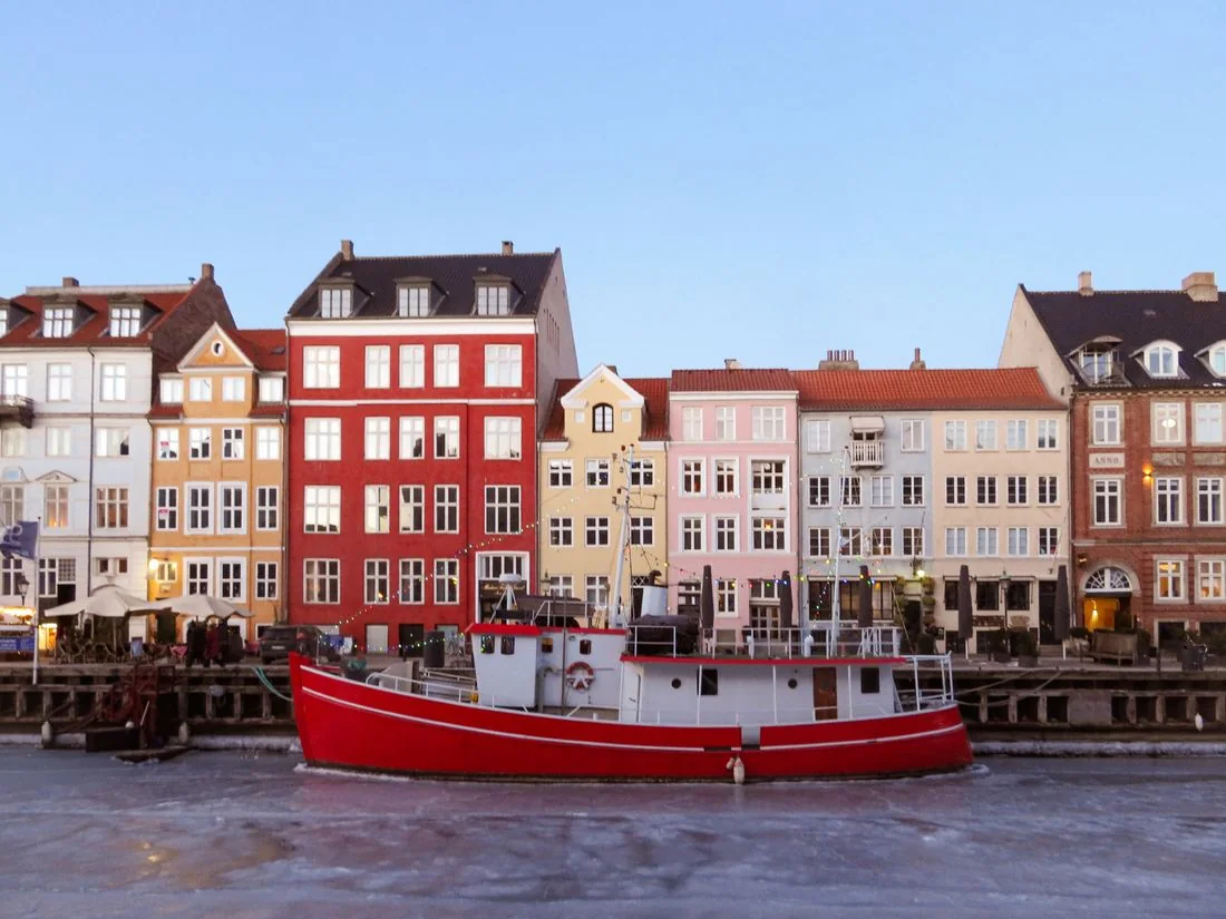 Colourful waterfront buildings behind a red and white boat