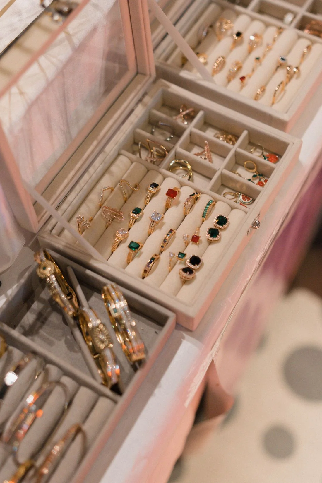 Rings and bangles in the compartments of an open jewellery box