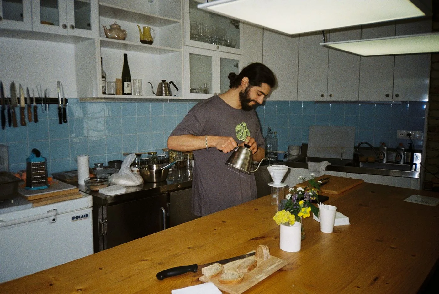 A person preparing coffee beside a kitchen island