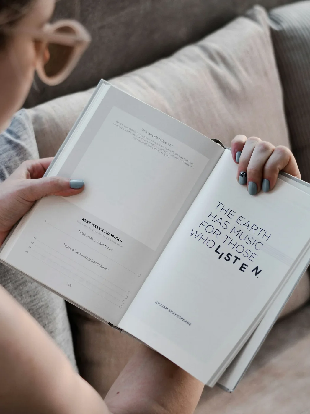Hands holding an open book with printed text