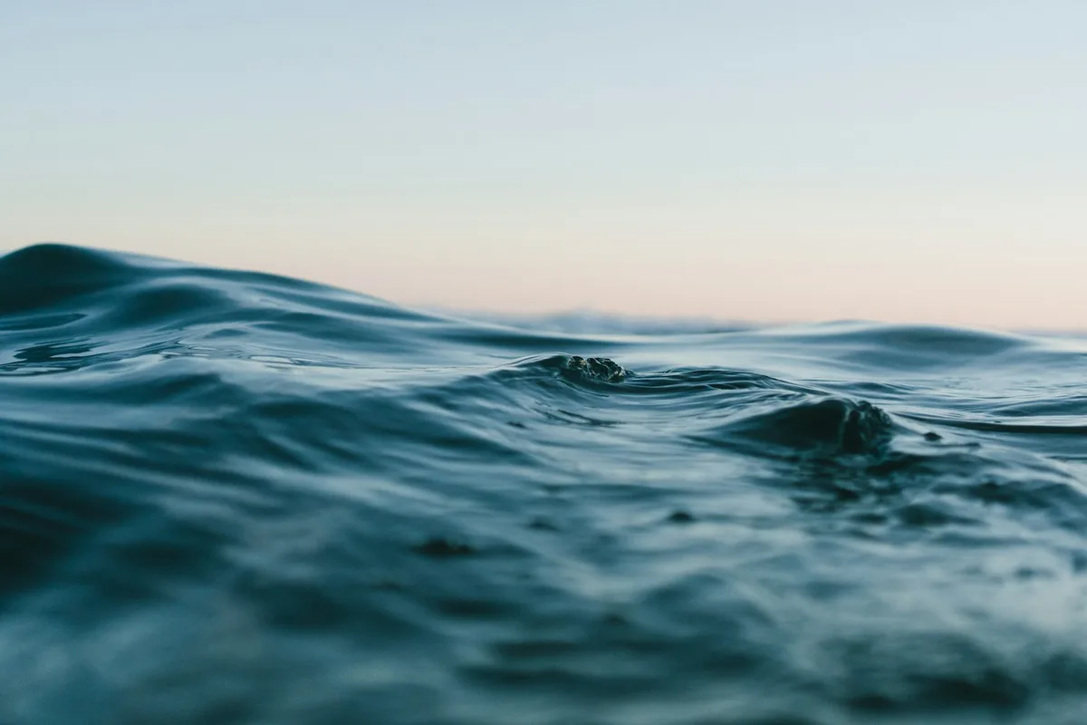 Low ocean waves beneath a pale sky