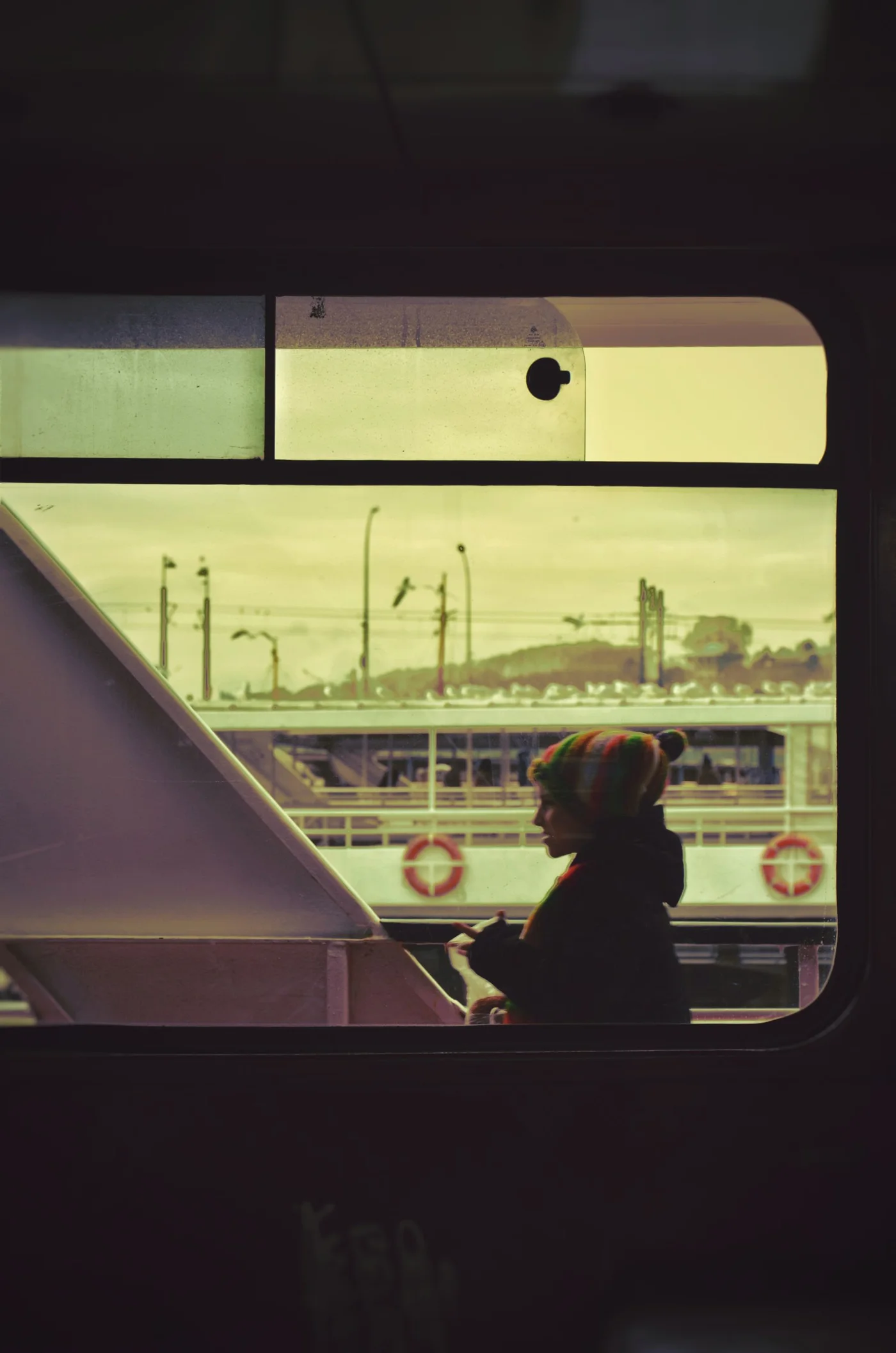 Silhouetted person wearing a hat seated beside a large terminal window