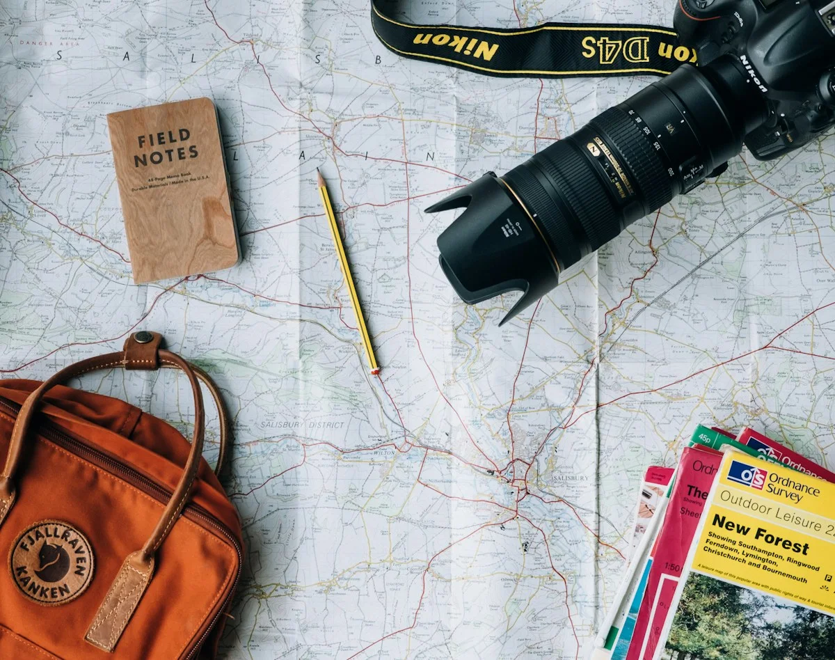 Travel map with a camera, notebook and leather bag